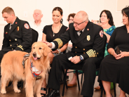 Chief Fuller petting Negan the Therapy dog while listening to the final tone-out.